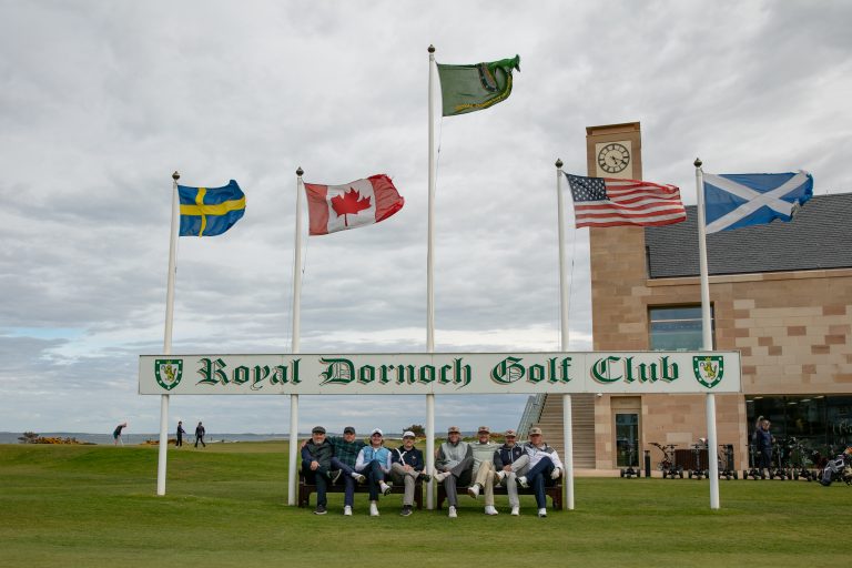 Group photo at the Royal Dornoch first tee sign during a Scotland golf tour