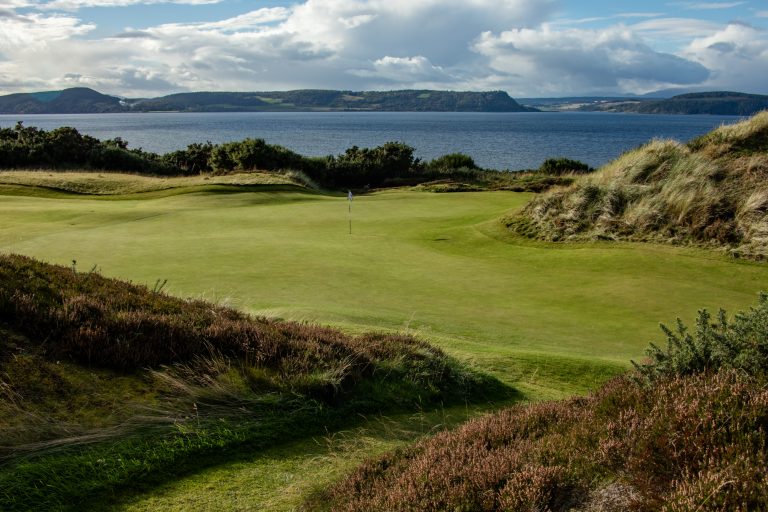 Castle Stuart’s 8th green with the Moray Firth in the background.