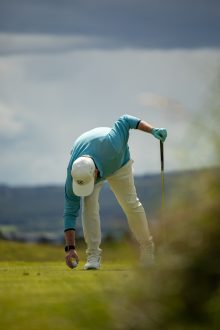 Golfer teeing up his ball on the second hole at Royal Dornoch