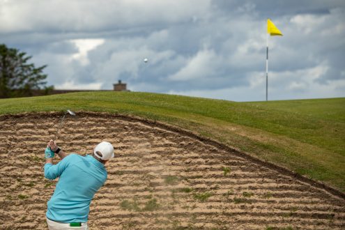 Golfer playing from a bunker on the second hole at Royal Dornoch